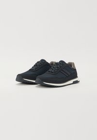 Marineblå mesh-sneakers med strukturerte detaljer, grå elementer og hvite gummisåler. Har tradisjonell snøring og en støttende design.