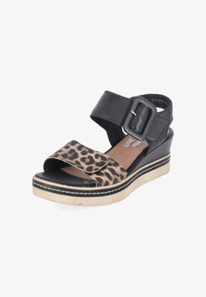 Sandale compensée noire et beige avec bride avant imprimé léopard, bride de cheville noire avec grande boucle et semelle épaisse blanche.