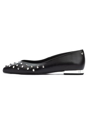 Bailarina de cuero negro con punta afilada, adornada contachuelas plateadas, y un bajo tacón cuadrado con un acento metálico.