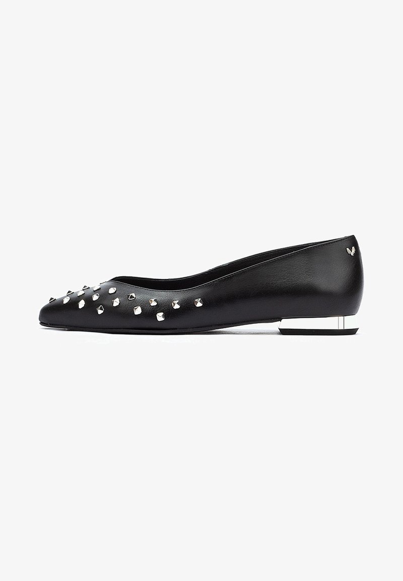 Ballerines noires en cuir avec un bout pointu, ornées de clous en argent, et un petit talon bloc avec un accent métallique.