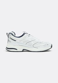 Baskets de sport blanches et noires avec tige en mesh, fermeture à lacets, semelle coussinée et languettes sur la languette et le talon.