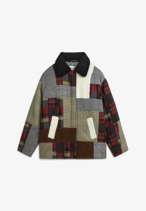 Veste en patchwork multicolore présentant diverses textures et motifs, y compris des carreaux et des accents pelucheux, avec un col noir et des poches avant.