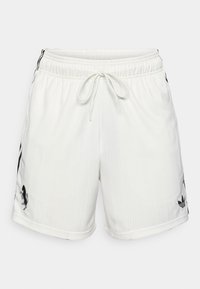 Pantalones cortos deportivos blancos con diseño texturizado, cinturilla elástica, cordón ajustable y detalles de logotipo negro en el lateral.