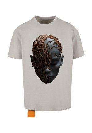 Light gray t-shirt featuring a graphic print of a face with dark skin and intricate, brown snake-like details covering one side.
