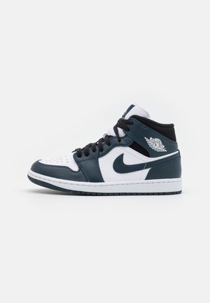 Środkowo-wysokie buty Nike Air Jordan w bieli i ciemnym morskim kolorze z czarnymi sznurowadłami i logo Nike na białym tle.