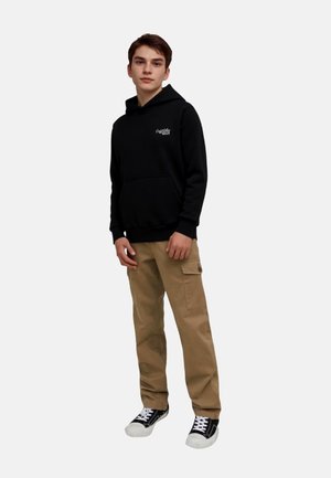 Black hoodie with front pocket and logo, paired with khaki cargo pants and black sneakers with white soles. Simple, casual outfit.