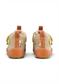 Kinderschuhe aus beigem und grünem Netzmaterial mit orangen Gummisohlen. Sie verfügen über eine Schlaufe an der Rückseite und dekorative Akzente an den Seiten.