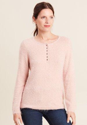 Maglione rosa chiaro, morbido e soffice, con scollatura rotonda, maniche lunghe e una pattina con cinque bottoni sul davanti. Texture morbida e orlo sfilacciato.