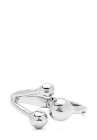 Anillo de metal plateado que presenta un diseño suave y curvado con tres acentos esféricos de diferentes tamaños dispuestos de manera asimétrica.