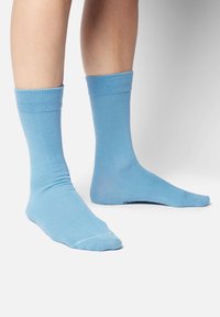 Niebieskie skarpetki bawełniane z prążkowanym mankietem, gładką fakturą i klasyczną długością do kostek. Design charakteryzuje się jednolitym kolorem bez wzorów.