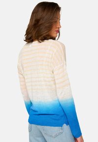 Gestreifter Pullover in sanftem Beige und blauem Farbverlauf, mit langen Ärmeln und lockerer Passform. Das Material wirkt weich und leicht.