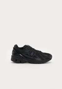 Black athletic shoe with mesh upper and synthetic accents. Features textured sole and padded collar, designed for comfort and support.