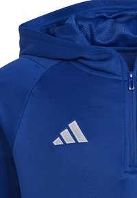 Felpa sportiva blu con chiusura a zip, cappuccio foderato in rete e logo ricamato bianco con tre strisce sulla parte sinistra del petto.