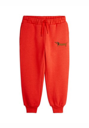 Pantaloni sportivi rossi con cintura elastica e lacci, polsini elastici e ricamo di un bassotto marrone sulla coscia sinistra.