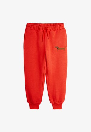 Pantaloni sportivi rossi con cintura elastica e lacci, polsini elastici e ricamo di un bassotto marrone sulla coscia sinistra.