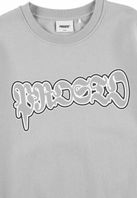 Jasnoszary sweatshirt z okrągłym dekoltem. Posiada duży graficzny logo w białym i szarym kolorze z artystyczną, stylizowaną czcionką.