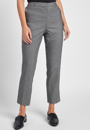 Pantalons gris sur mesure avec une coupe droite, fabriqués en tissu texturé. Comprend un devant plat et des poches latérales, associés à des mocassins noirs.
