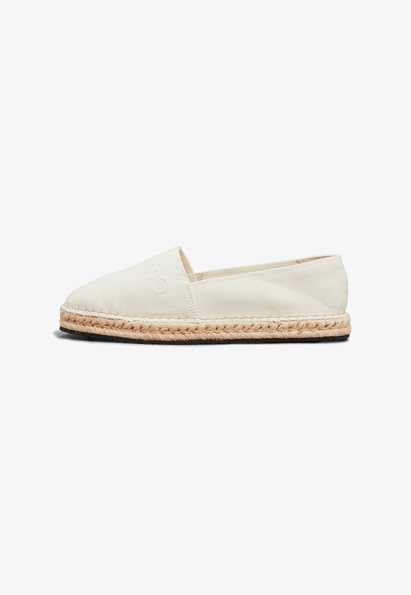 Espadrillas in tela off-white con suola in juta intrecciata e fondo in gomma nera. Presentano un design cucito con un branding discreto sul lato.