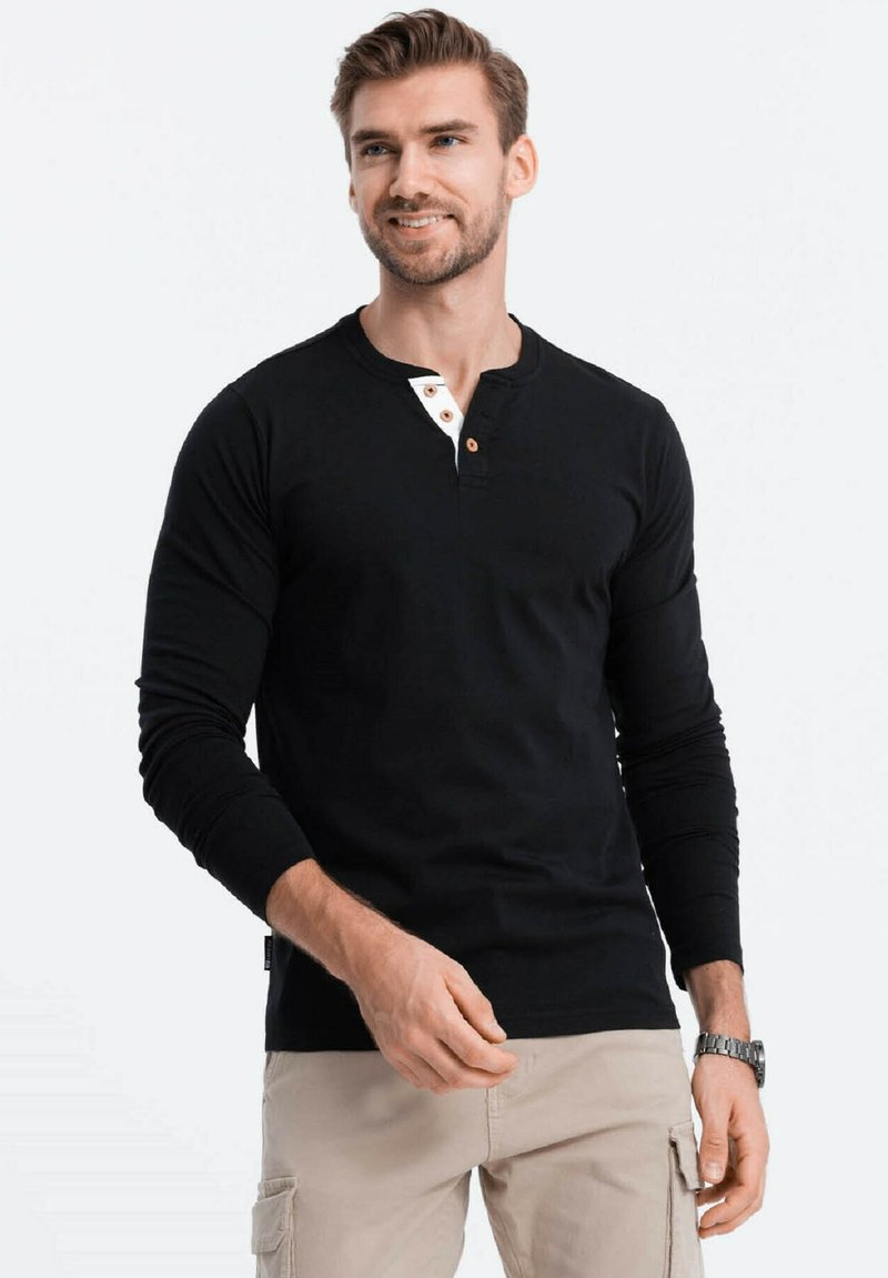 Schwarzes Langarm-Henley-Shirt mit einer zwei Knopf großen Knopfleiste mit weißen Akzenten, aus weichem Material und mit taillierter Passform.