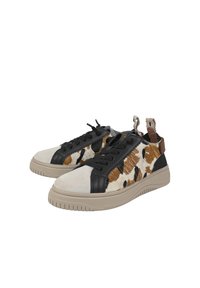 Sneaker in pelle nera e pelle di mucca maculata con suola in gomma beige, dotate di lacci frontali e linguette posteriori per una facile calzata.