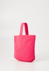Sac fourre-tout en tissu rose avec une forme structurée, un fond plat et deux courtes poignées. Texture lisse sans motifs ni quincaillerie visibles.