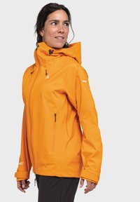 Orange wasserdichte Jacke mit hohem Kragen, verstellbarem Kapuzen und doppelt mit Reißverschluss versehenen Seitentaschen. Verfügt über einen strukturierten Stoff und Logodetails.