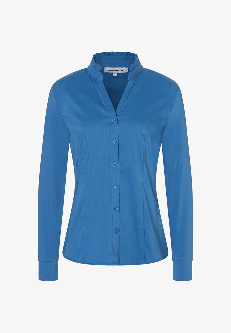 Chemise bleue à manches longues avec boutons, col court à volants et taille cintrée, présentée sur fond blanc uni.