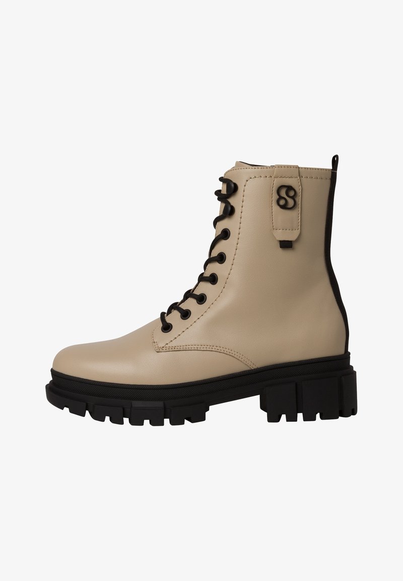 Botte de combat beige en cuir à lacets, semelle noire, semelle épaisse et détail de logo noir près de la languette de cheville.