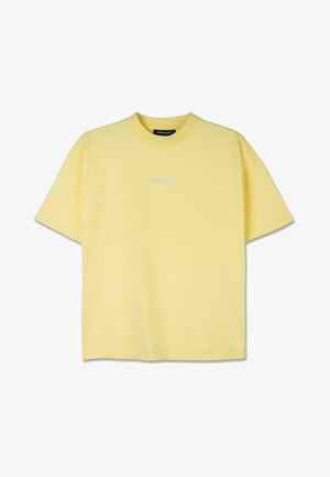 Rumena bombažna majica s kratkimi rokavi, krožnim izrezom in majhnim modrim logotipom na prsih. Gladka tekstura in sproščen kroj.