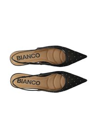 Mustad rihmikud teravate varvastega, täpilise mustriga ja pehme pruuni sisetallaga. Sisetallal on brändi silt.