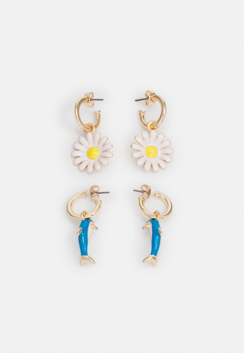 Brincos em forma de argola dourada, apresentando uma margarida branca com um centro amarelo e um accentuador em forma de golfinho azul. Feitos de metal e esmalte.