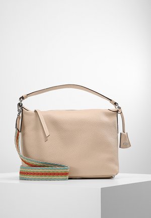 Sac à bandoulière en cuir beige avec une poignée couleur cuir clair et une bandoulière amovible en tissu rayé multicolore sur un piédestal blanc.