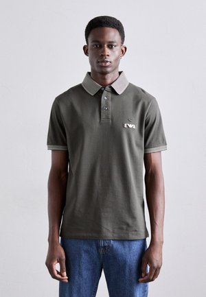 Donkergroen poloshirt van katoen, met een gestreepte kraag en mouwmanchetten, een placket met drie knopen en een geborduurd logo op de borst.