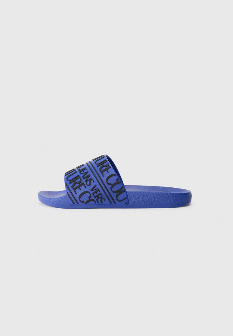 Blue rubber slide sandal with a wide strap featuring black text in a repeating pattern. Flat sole with a textured surface for grip.