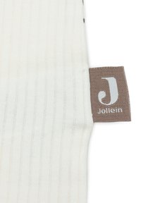 Tissu côtelé de couleur crème avec une texture douce. Présente une étiquette marron avec un "J" blanc et le texte "Jollein".