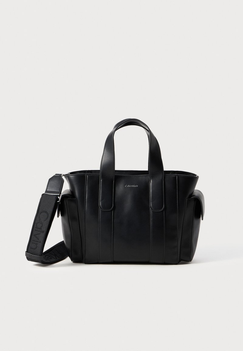 Svart lær tote bag med doble topphåndtak og justerbar skulderrem. Har vertikale sømmer og et minimalistisk design. Uthevet logodetalj.