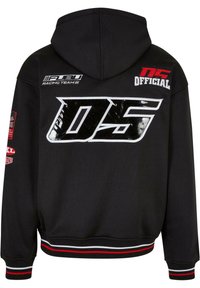 Schwarzer Kapuzenpullover mit einem großen, glänzenden "DS"-Logo auf dem Rücken. Mit roten und weißen gestreiften Akzenten an den Bündchen und am Saum. Enthält Aufnäher.