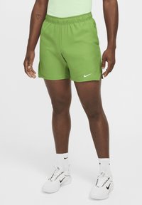 Vihreät urheilushortsit, joissa on joustava vyötärö, sivuleikkaukset ja valkoinen Nike-logo vasemmalla puolella. Sujuva, kevyt materiaali.