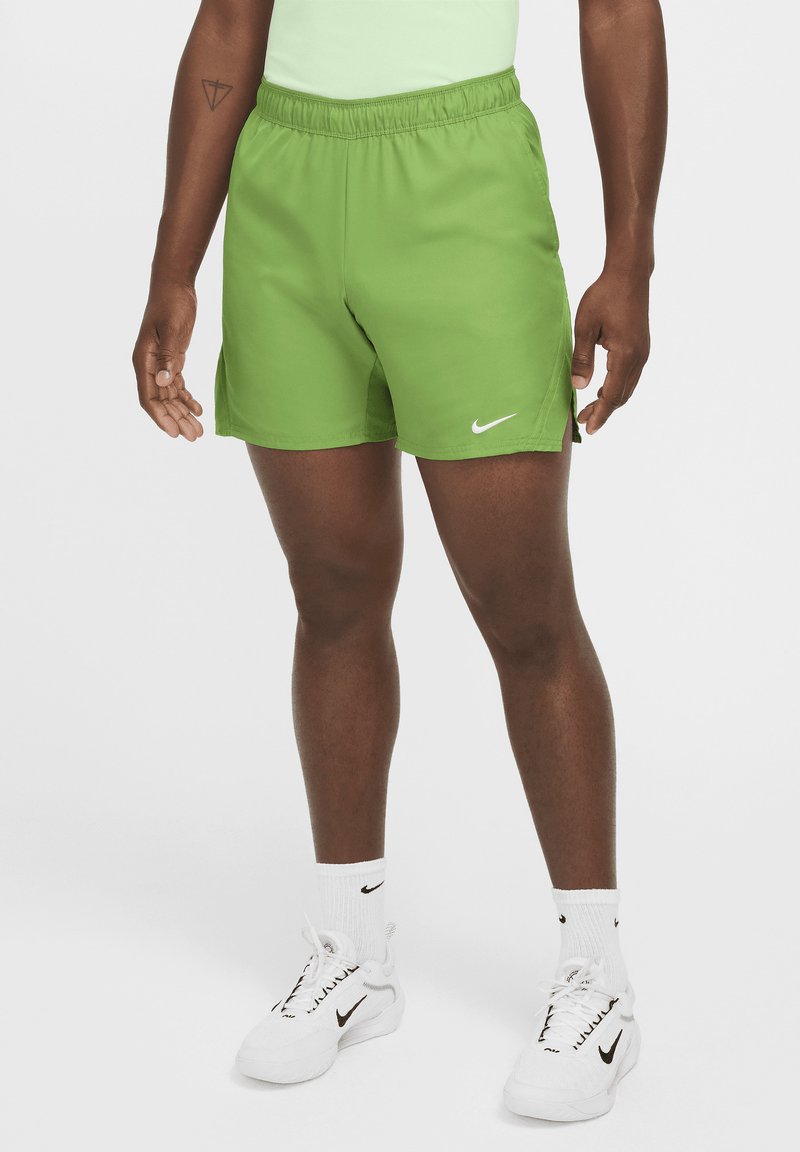 Vihreät urheilushortsit, joissa on joustava vyötärö, sivuleikkaukset ja valkoinen Nike-logo vasemmalla puolella. Sujuva, kevyt materiaali.