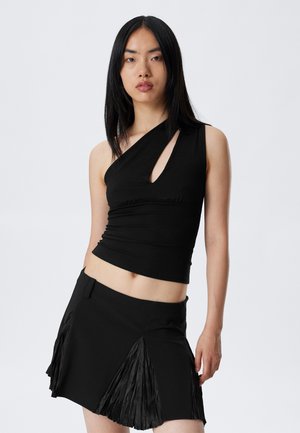 Black, one-shoulder top with a keyhole cutout and gathered texture, paired with a black pleated mini skirt featuring side slits.
