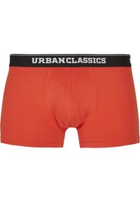 Rote Baumwollboxershorts mit einem schwarzen Bund, auf dem "URBANCLASSICS" in weißer Schrift steht. Das Design umfasst eine konturierte Tasche.