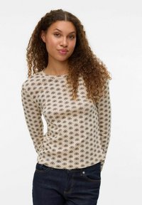 Camisa de manga larga color beige claro con un patrón floral en marrón oscuro. Presenta un cuello redondo y un diseño ajustado, fabricada con una suave tela texturizada.