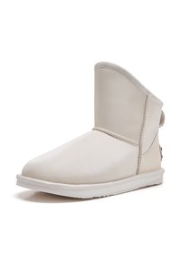 Biele kožené členkové topánky s okrúhlou špičkou, mäkkým zvrškom a kontrastnou bielou gumovou podrážkou. Obsahuje viditeľné švy a zadný pútko na obutie.