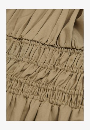 Beezist kanga smockimise õmblustega, millel on kogutud tekstuur ja vertikaalsed voltid. Pehme ja kerge materjal, millel on sile viimistlus.