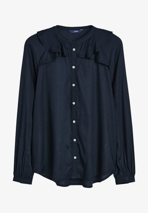 Chemise boutonnée marine en tissu texturé, avec un col froncé, des manches longues avec des poignets élastiques, et des boutons blancs sur le devant.