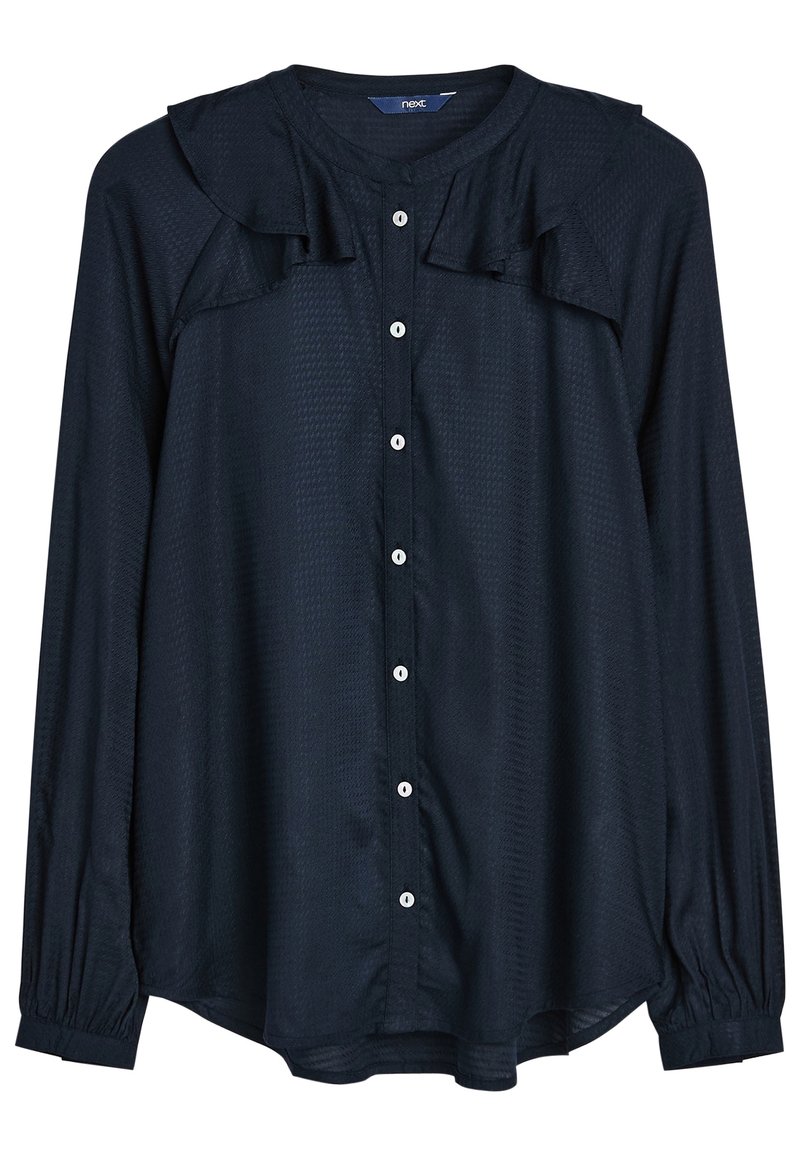 Camicia blu navy con tessuto testurizzato, caratterizzata da un colletto a volant, maniche lunghe con polsini elastici e bottoni bianchi sul davanti.