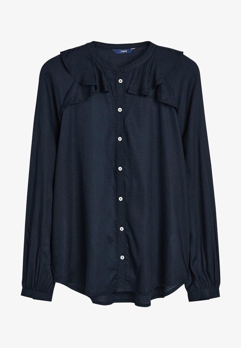 Camicia blu navy con tessuto testurizzato, caratterizzata da un colletto a volant, maniche lunghe con polsini elastici e bottoni bianchi sul davanti.