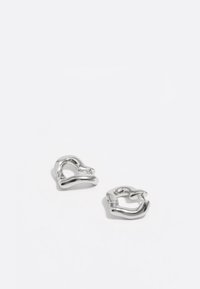 Pendientes de plata con un diseño de corazón retorcido, que presentan una superficie pulida y formas redondeadas que reflejan la luz.