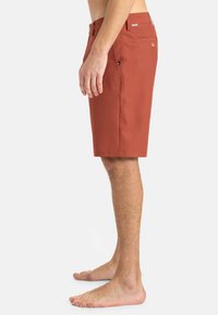 Herren-Shorts in rot-braun, aus leichtem Material gefertigt, mit geradem Schnitt, Seitentaschen und einem Knopfverschluss für Praktikabilität.
