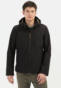 Zwarte jas met een capuchon, voorzien van een rits aan de voorkant en meerdere zakken. Gemaakt van lichtgewicht stof met een soepele textuur en minimale details.